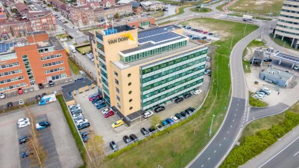 Luchtfoto van het kantoorgebouw van Van Dorp aan de Fascinatio Boulevard met omliggende parkeerplaatsen en wegen.
